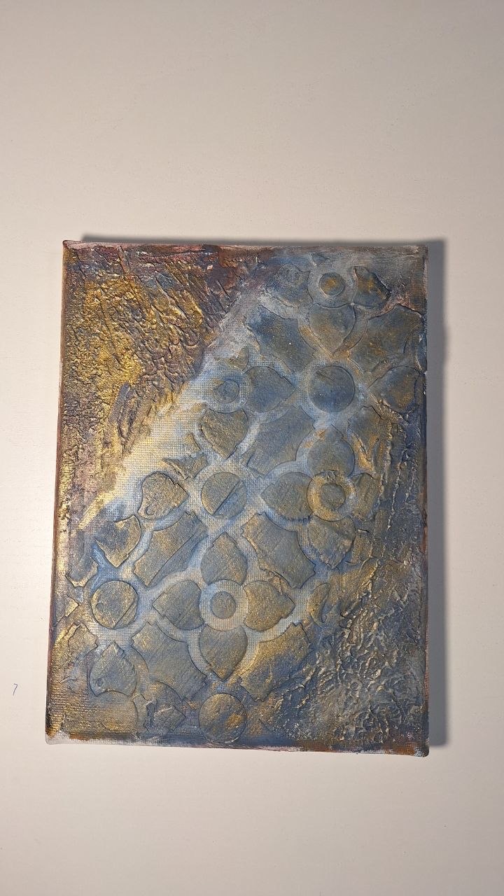 Close-up of a layered blue and gold textured artwork
